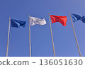 Flags in the sky on tall flagpoles 136051630