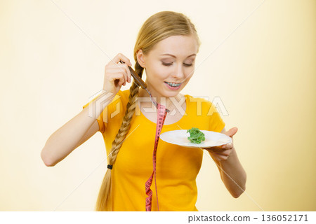 Woman on diet holding plate with lettuce 136052171