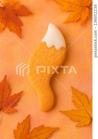 可愛的糖霜餅乾，形狀像狐狸尾巴，周圍環繞著秋葉。 136052239