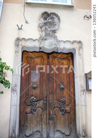 Historic wooden doorway with ornate stone sculpture detail Historic wooden doorway with ornate stone sculpture detail 136052243
