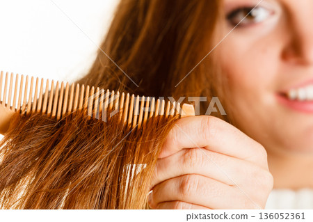 Woman combing and pulls hair. 136052361