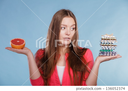 Woman with diet weight loss pills and grapefruit. Woman with diet weight loss pills and grapefruit. 136052374