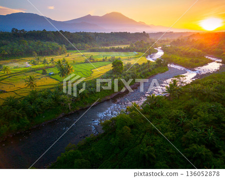 Beautiful morning view in Indonesia, panoramic landscape of rice fields with mountain ranges and clear sky 136052878