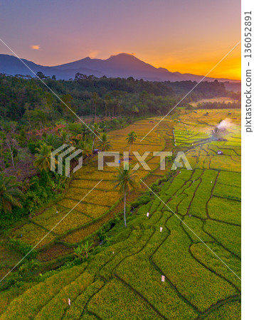 Beautiful morning view in Indonesia, panoramic landscape of rice fields with mountain ranges and clear sky Beautiful morning view in Indonesia, panoramic landscape of rice fields with mountain ranges and clear sky 136052891