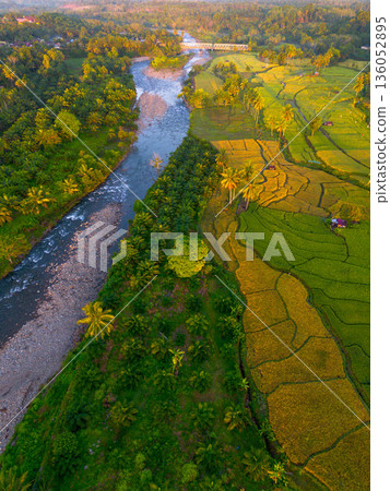 Beautiful morning view in Indonesia, panoramic landscape of rice fields with mountain ranges and clear sky Beautiful morning view in Indonesia, panoramic landscape of rice fields with mountain ranges and clear sky 136052895