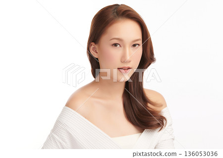 A beautiful young Asian woman with clean, fresh skin against a white background. Skincare, facial treatment, cosmetology, beauty, and spa. An elegant portrait of an Asian woman. 136053036