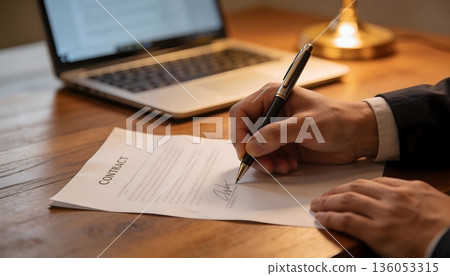 一位商人正在辦公桌前簽署文件。 136053315