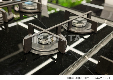 Modern black glass gas stovetop with dual burners and cast iron grates Modern black glass gas stovetop with dual burners and cast iron grates 136054293