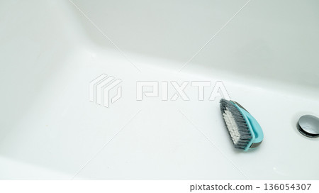 White bathtub interior with cleaning brush near drain White bathtub interior with cleaning brush near drain 136054307