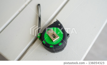 Green and black tape measure on white surface Green and black tape measure on white surface 136054323