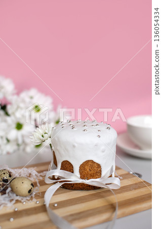 Iced easter cake with flowers and quail eggs on wooden board Iced easter cake with flowers and quail eggs on wooden board 136054334