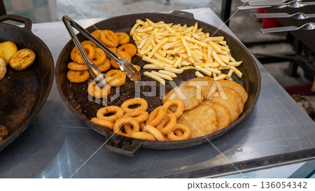 Variety of fried foods on display: onion rings, french fries, hash browns Variety of fried foods on display: onion rings, french fries, hash browns 136054342