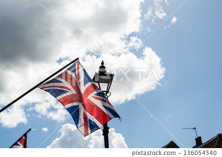 The Union Jack, the British flag, fluttering under the dazzling sunlight in the streets of Windsor, a suburb of London The Union Jack, the British flag, fluttering under the dazzling sunlight in the streets of Windsor, a suburb of London 136054540