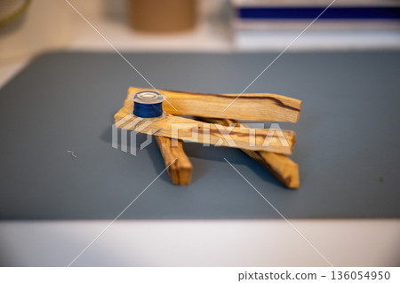 Minimal still life with wooden sticks and blue thread spool creating calm handmade craft composition Minimal still life with wooden sticks and blue thread spool creating calm handmade craft composition 136054950