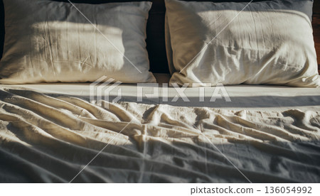 Clean white linen bed and pillows in the morning light 136054992