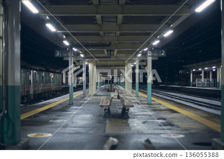 A train stopping at a platform at night 136055388