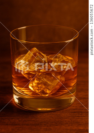 將金黃色威士忌倒入加冰的岩石杯中 136055672