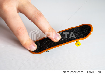 children's hands playing with a toy fingerboard, developing fine motor skills, selective focus children's hands playing with a toy fingerboard, developing fine motor skills, selective focus 136055709