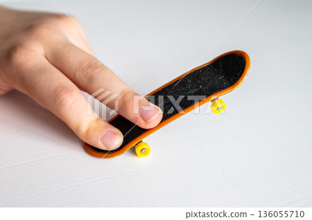 children's hands playing with a toy fingerboard, developing fine motor skills, selective focus 136055710