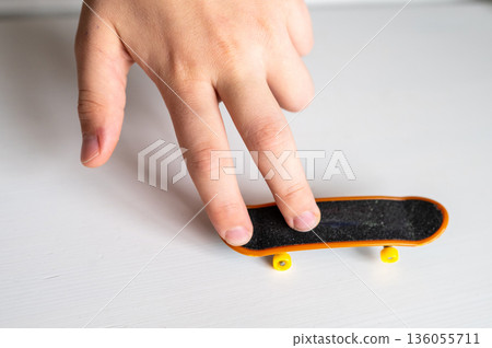 children's hands playing with a toy fingerboard, developing fine motor skills, selective focus 136055711