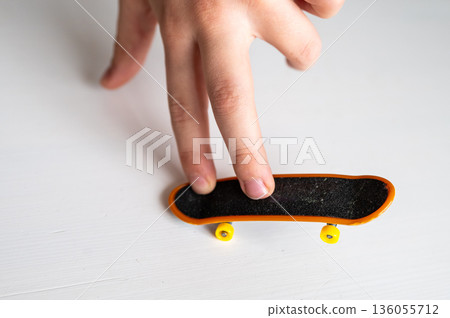 children's hands playing with a toy fingerboard, developing fine motor skills, selective focus 136055712
