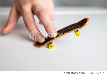 children's hands playing with a toy fingerboard, developing fine motor skills, selective focus 136055714