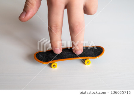 children's hands playing with a toy fingerboard, developing fine motor skills, selective focus 136055715