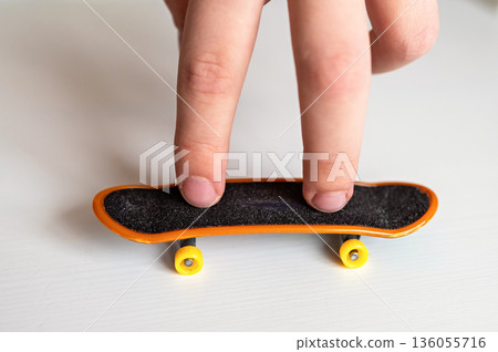children's hands playing with a toy fingerboard, developing fine motor skills, selective focus children's hands playing with a toy fingerboard, developing fine motor skills, selective focus 136055716