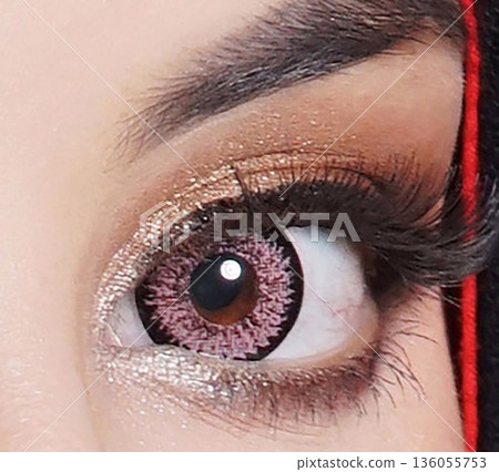 striking close up of a woman eyes accentuated by pink contact lenses, bold lashes, and shimmering makeup. Red framing the gaze, conveying fashion, confidence, and contemporary beauty striking close up of a woman eyes accentuated by pink contact lenses, bold lashes, and shimmering makeup. Red framing the gaze, conveying fashion, confidence, and contemporary beauty 136055753