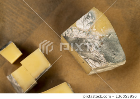 an old spoiled cheese with a lot of colorful mold, an inedible and dangerous cheese that was spoiled during the improper storage, the cheese is covered with mold dangerous to health an old spoiled cheese with a lot of colorful mold, an inedible and dangerous cheese that was spoiled during the improper storage, the cheese is covered with mold dangerous to health 136055956