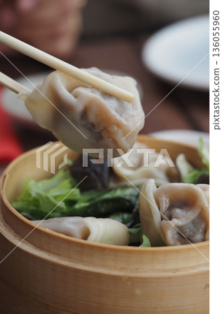 Dumplings served in a bamboo basket with chopsticks Dumplings served in a bamboo basket with chopsticks 136055960