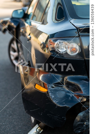 Detailed close-up of crushed automotive body panel with visible deformation, scratches, and paint damage after collision Detailed close-up of crushed automotive body panel with visible deformation, scratches, and paint damage after collision 136056439
