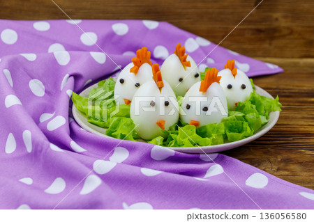 Funny easter breakfast with boiled eggs as chicks on wooden table 136056580