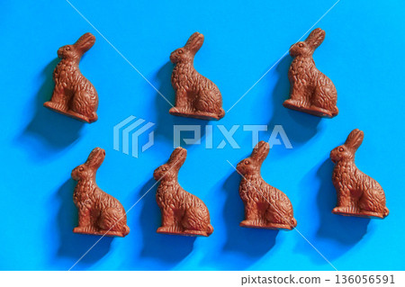 Easter chocolate bunnies on blue background. Top view 136056591