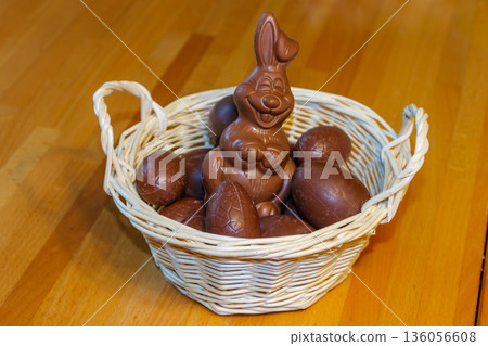 Basket with Easter eggs and Easter bunny on wooden table 136056608
