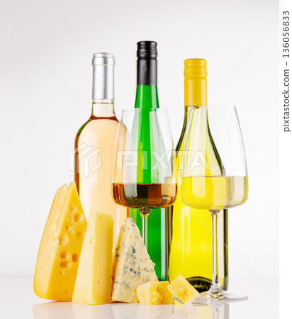 Assorted cheeses and wine on white background Assorted cheeses and wine on white background 136056833