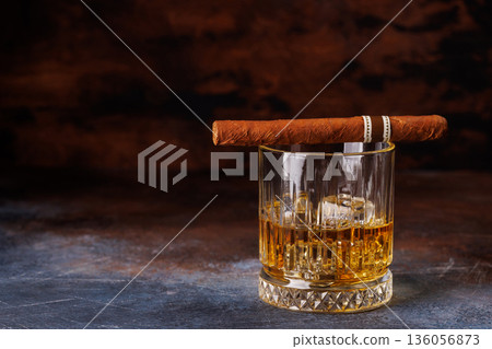 Glass of whiskey with ice and cigar 136056873