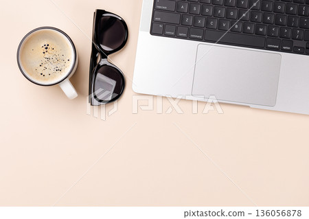 A clean and minimal desk setup featuring a laptop and a coffee cup 136056878