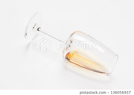 Wine glass with white wine lying on white background Wine glass with white wine lying on white background 136056937