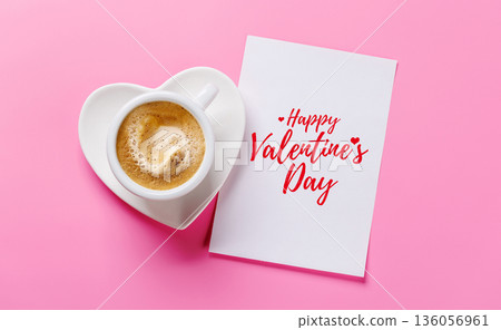 Heart-shaped cappuccino cup and greeting card on pink background 136056961