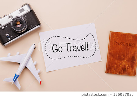 Travel-themed flat lay with card, camera, toy airplane Travel-themed flat lay with card, camera, toy airplane 136057053