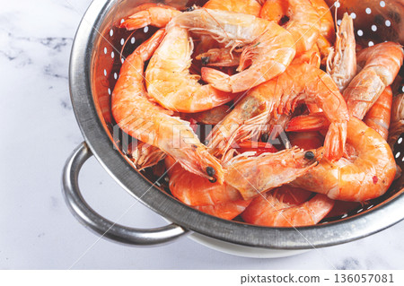 freshly frozen shrimp in a metal colander, for cooking, top view, close-up, on a marble table, no people, 136057081