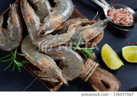 Fresh raw, white-footed shrimp, tiger prawns vannamei, on a wooden cutting board, with lime slices, and seasonings, Fresh raw, white-footed shrimp, tiger prawns vannamei, on a wooden cutting board, with lime slices, and seasonings, 136057087