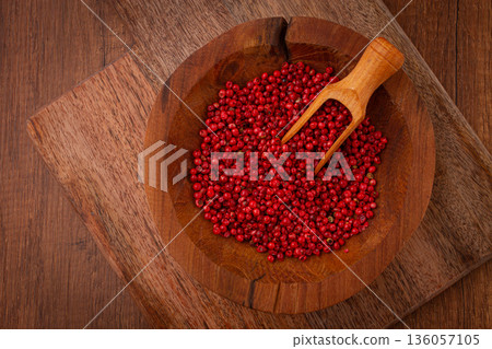 Bright red peppercorns, in a wooden bowl, with a small wooden tray, 136057105
