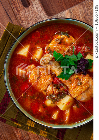 Souzi soup. Georgian dish, meat with oats, tomato sauce and herbs, on a wooden table Souzi soup. Georgian dish, meat with oats, tomato sauce and herbs, on a wooden table 136057108