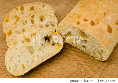 Ciabatta - Italian bread with cheese cut into slices on a wooden board Ciabatta - Italian bread with cheese cut into slices on a wooden board 136057226