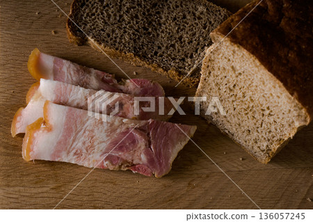 Black bread and salted lard with strips of meat on a wooden board Black bread and salted lard with strips of meat on a wooden board 136057245
