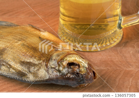 stockfish and glass of beer on a wooden board 136057305