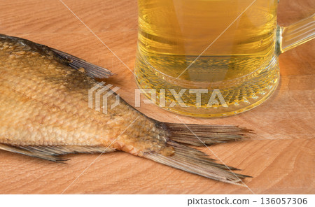 stockfish and glass of beer on a wooden board stockfish and glass of beer on a wooden board 136057306