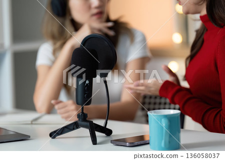 Two women are talking on a microphone Two women are talking on a microphone 136058037